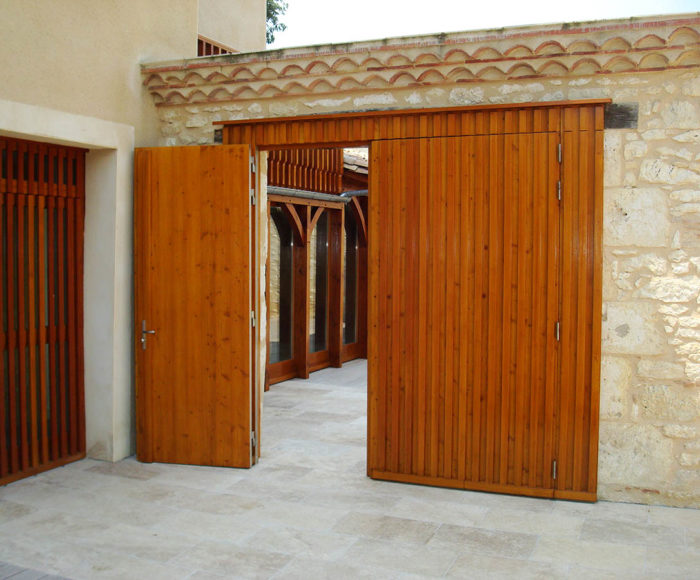 Portail en bois d'entrée extérieure à 2 vantaux avec un vantail ouvert sur un patio